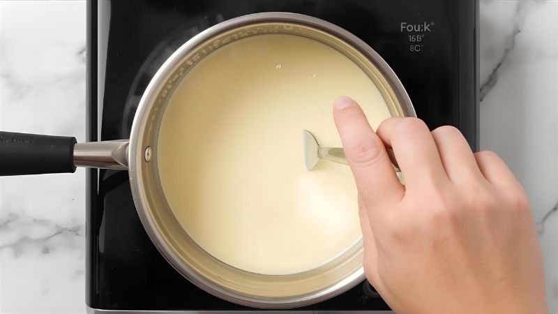 Heat your heavy cream in a small saucepan over medium-low heat. You want it warm but not boiling—aim for about 70°C (160°F) if you have a thermometer.